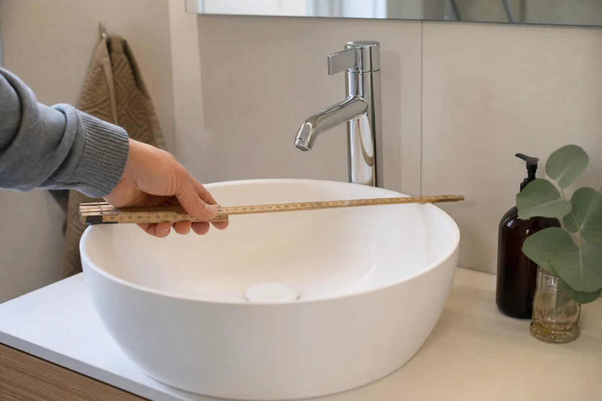 Mätning av avstånd vid tvättställsblandare med tumstock